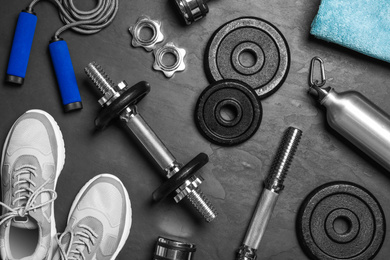Photo of Gym equipment on black background, flat lay