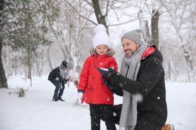 Father with his child spending time outside on winter day. Christmas vacation