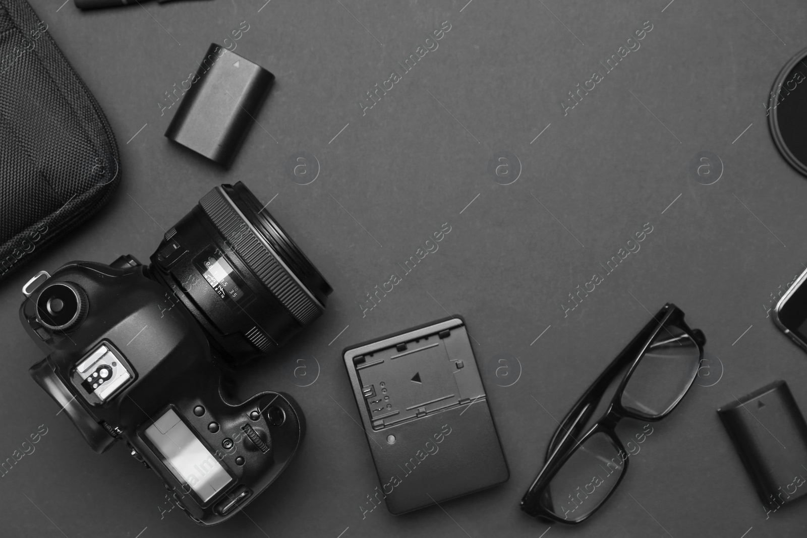 Photo of Flat lay composition with equipment for professional photographer on dark background. Space for text