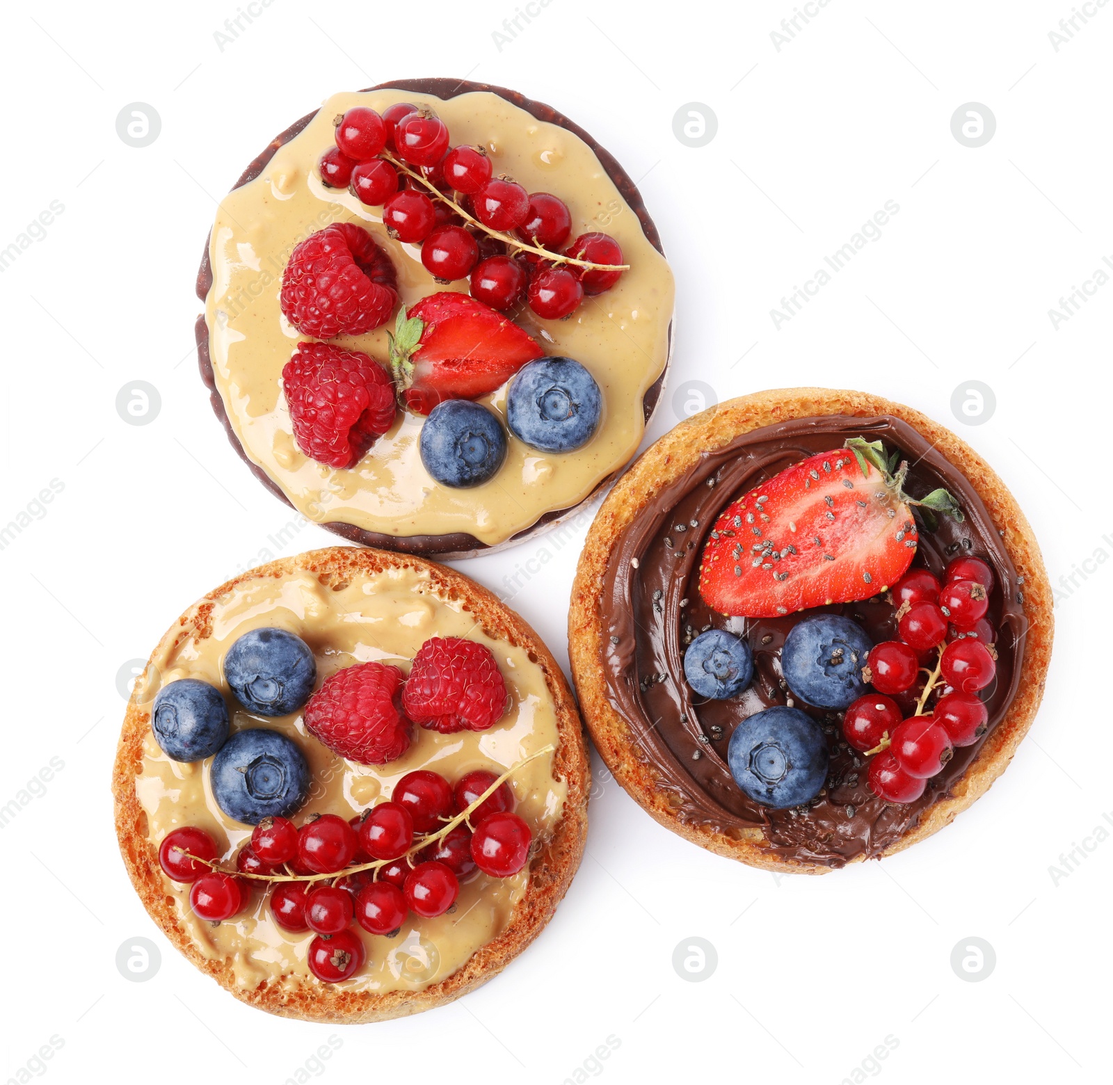 Photo of Tasty organic rusks and rice cake with different toppings on white background, top view