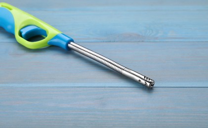 Photo of One gas lighter on light blue wooden table