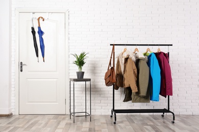 Stylish hallway interior with clothes on hanger stand