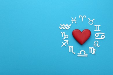 Photo of Zodiac signs and heart on light blue background, flat lay. Space for text