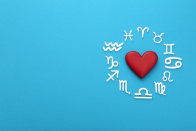 Zodiac signs and heart on light blue background, flat lay. Space for text