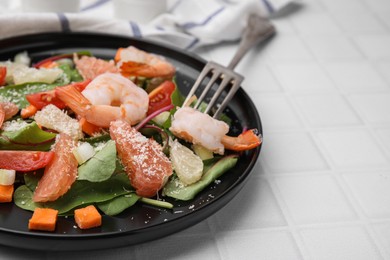 Photo of Delicious salad with pomelo, shrimps and tomatoes on white tiled table, closeup. Space for text