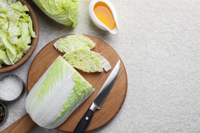 Fresh Chinese cabbages, oil and spices on light table, flat lay. Space for text