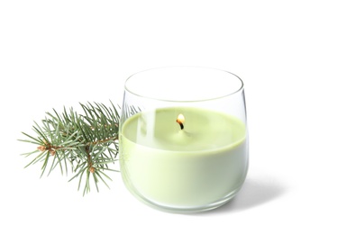 Photo of Green wax candle in glass holder and fir branch on white background