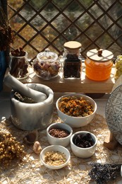 Many different dry herbs and flowers on table near window