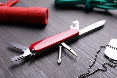 Photo of Modern compact portable multitool and accessories on wooden table