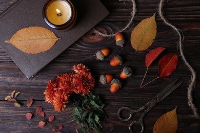 Flat lay composition with beautiful chrysanthemum flowers, autumn leaves and acorns on wooden table