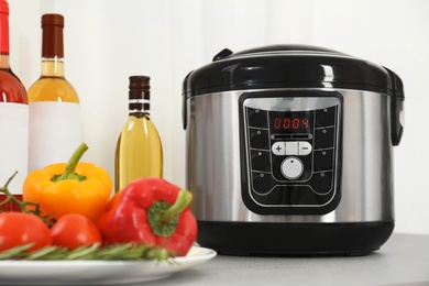 Modern multi cooker and products on kitchen table