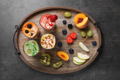 Photo of Tray with many different delicious smoothies and ingredients on grey table, top view
