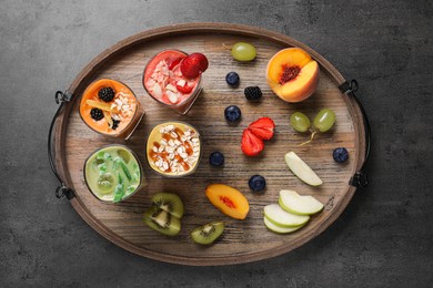 Tray with many different delicious smoothies and ingredients on grey table, top view