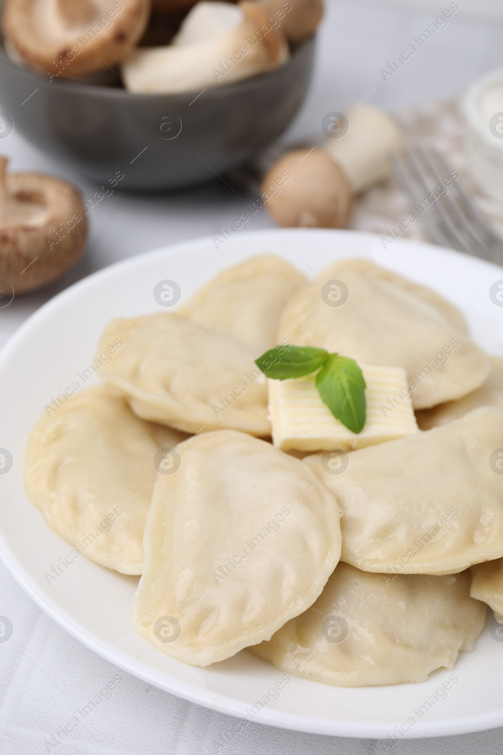 Photo of Delicious dumplings (varenyky) with tasty filling and butter on white table, closeup