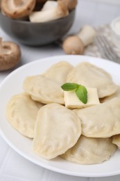 Delicious dumplings (varenyky) with tasty filling and butter on white table, closeup