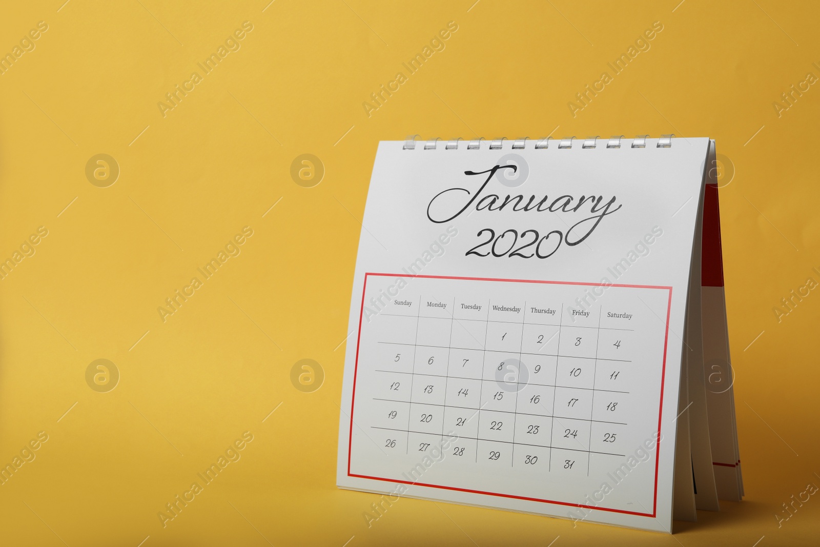 Photo of Paper calendar on yellow background, space for text. Planning concept