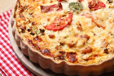 Tasty quiche with tomatoes and cheese on table, closeup