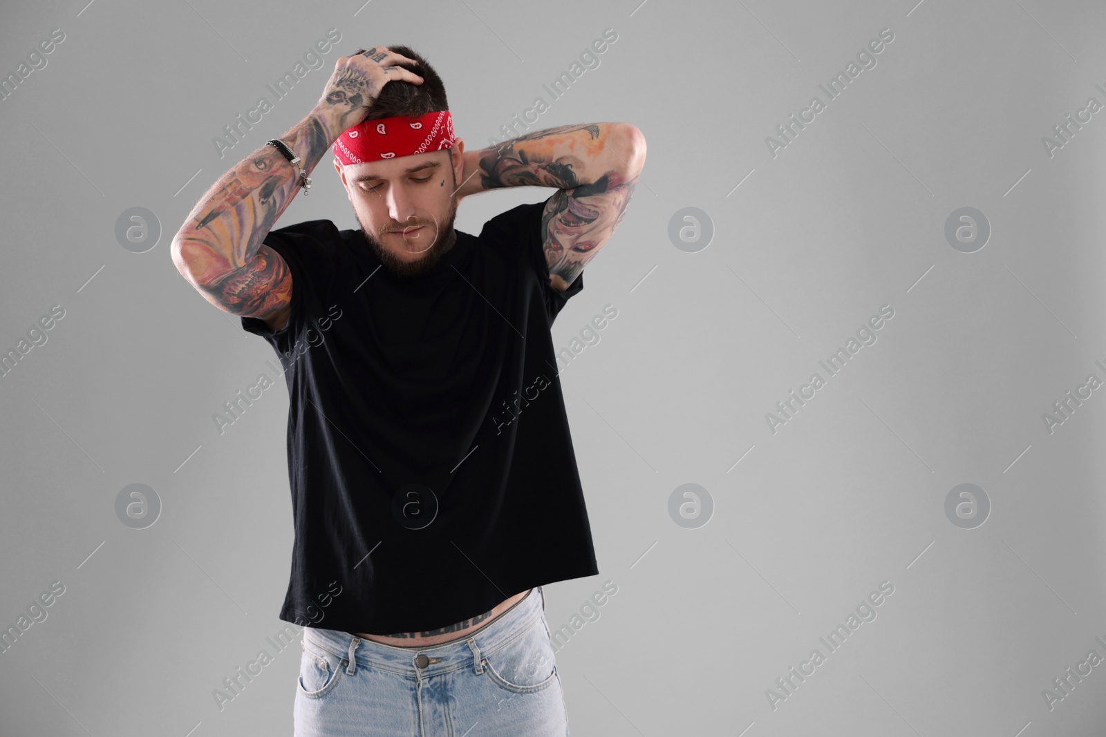 Photo of Handsome hipster man posing on light grey background. Space for text