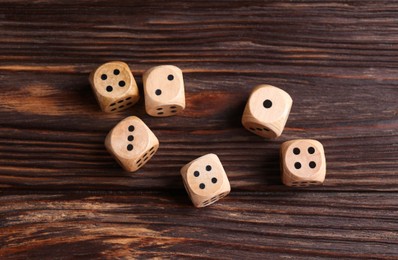 Photo of Many game dices on wooden table, flat lay