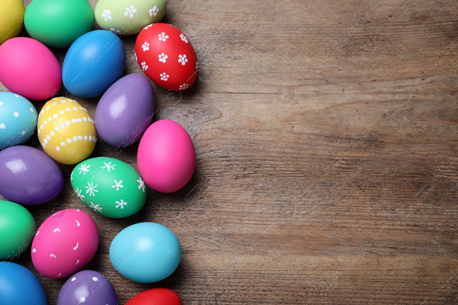 Photo of Colorful eggs on wooden background, flat lay with space for text. Happy Easter