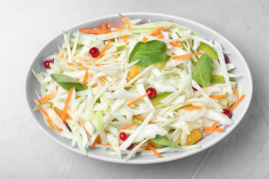 Photo of Fresh cabbage salad on light grey table, top view