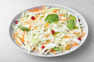 Fresh cabbage salad on light grey table, top view