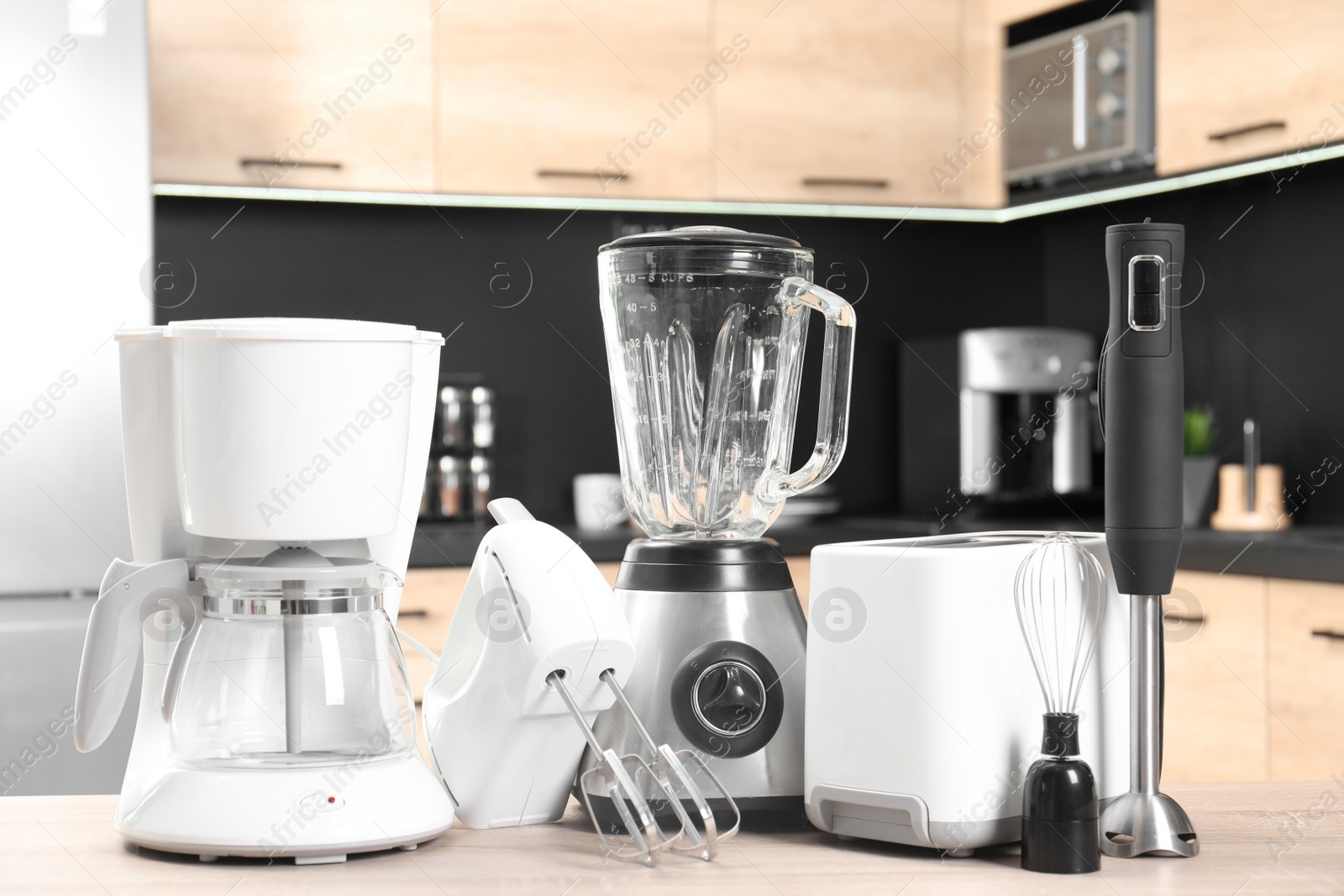 Photo of Modern domestic appliances on wooden table in kitchen