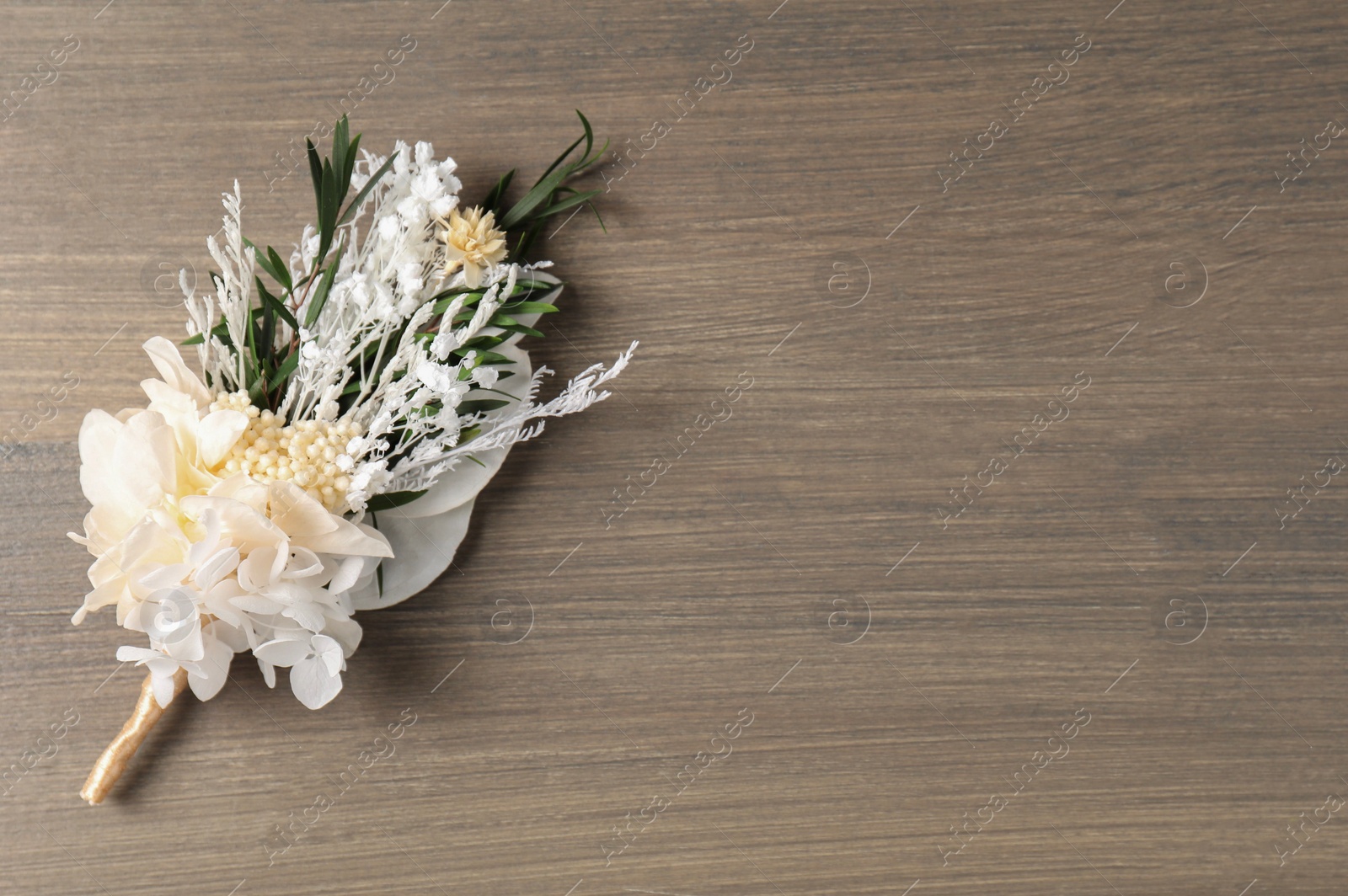 Photo of Beautiful boutonniere on wooden background, top view. Space for text