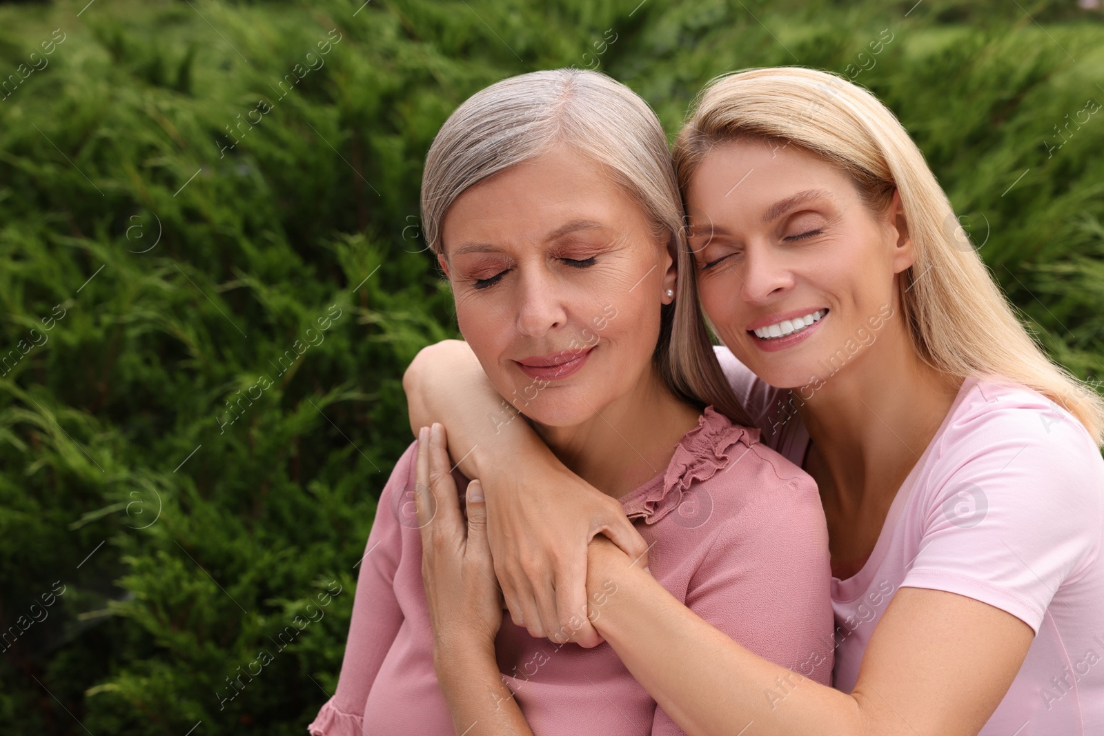 Photo of Happy mature mother and her daughter hugging outdoors