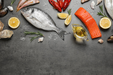 Photo of Fresh fish and seafood on grey table, flat lay. Space for text