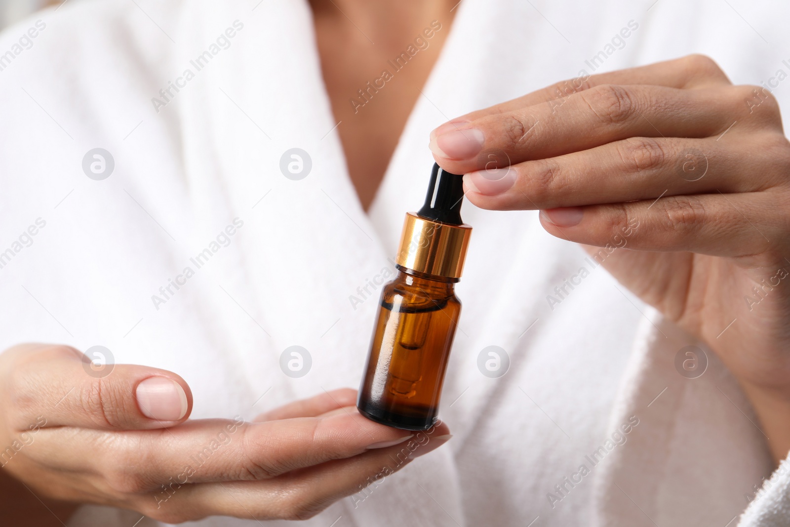 Photo of Woman with bottle of cosmetic serum, closeup