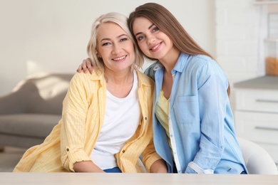 Portrait of young woman with her mature mother at home