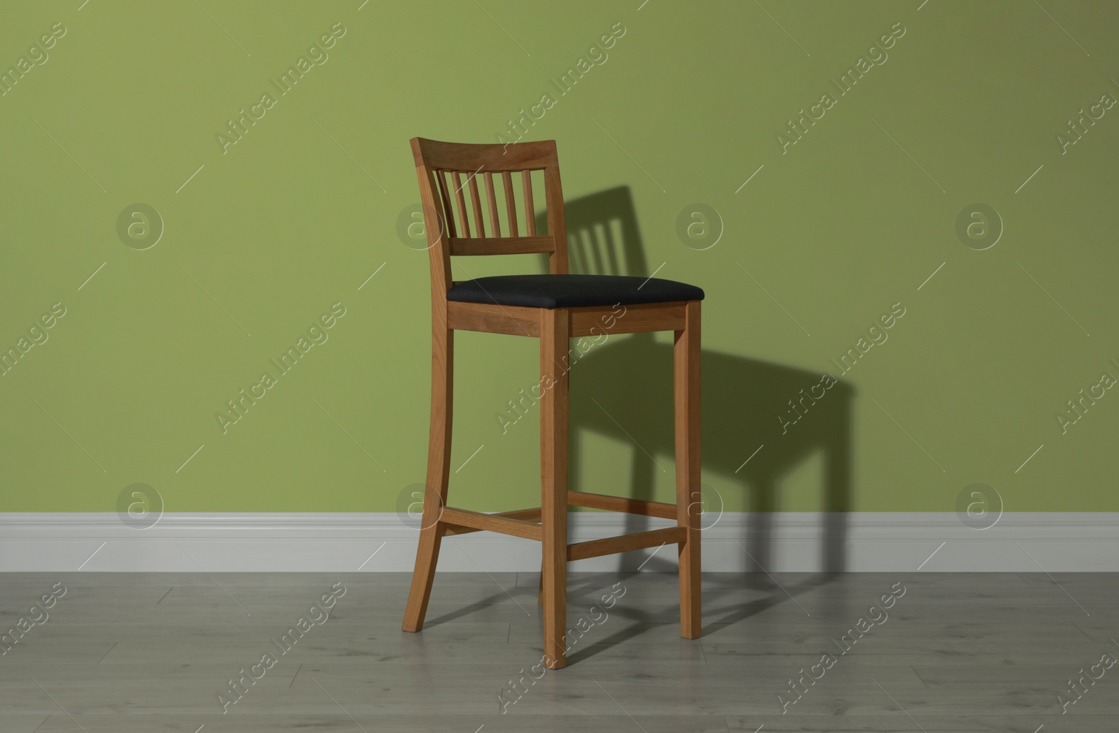 Photo of Stylish bar stool near light green wall indoors