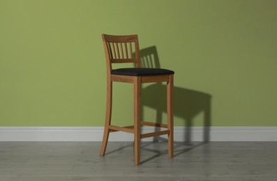 Photo of Stylish bar stool near light green wall indoors