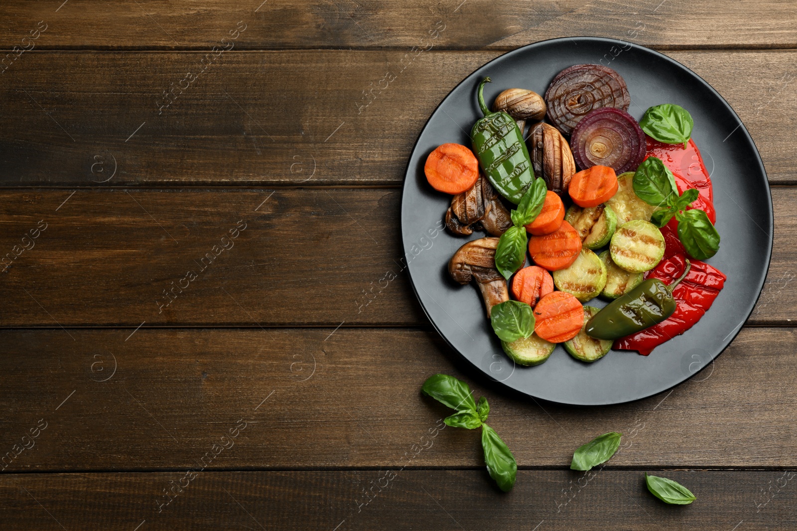 Photo of Delicious grilled vegetables on wooden table, flat lay. Space for text