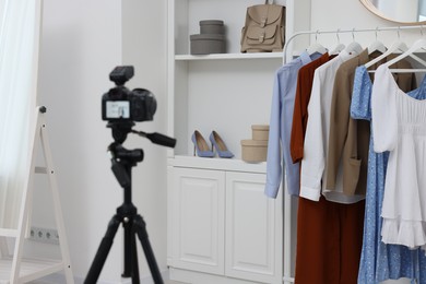 Fashion blogger's workplace. Shoes, clothes, camera and stylish furniture indoors