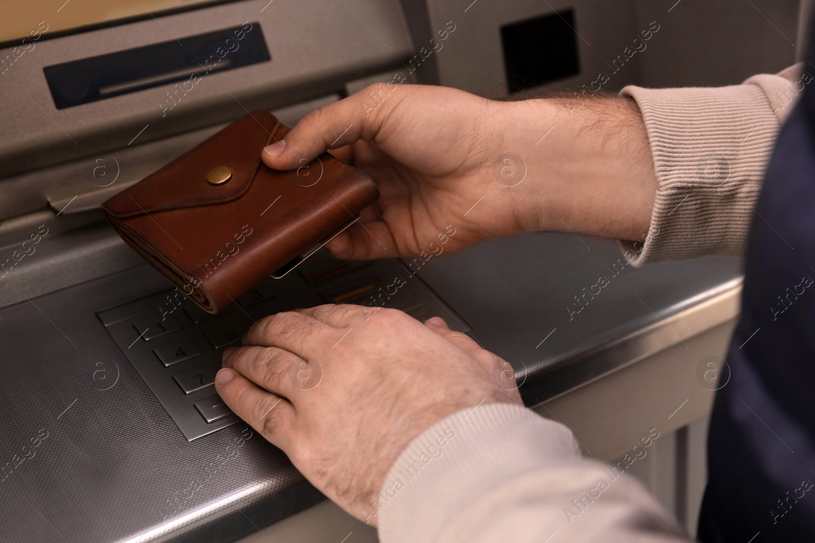 Photo of Man entering cash machine pin code, closeup