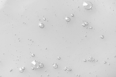 Photo of Hydrophilic oil with bubbles on white background, top view