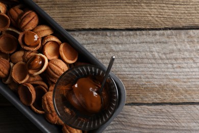 Photo of Making walnut shaped cookies. Cooked dough and caramelized condensed milk on wooden table, top view. Space for text