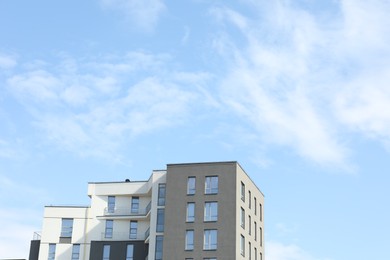 Photo of Modern building with big windows against blue sky outdoors, space for text