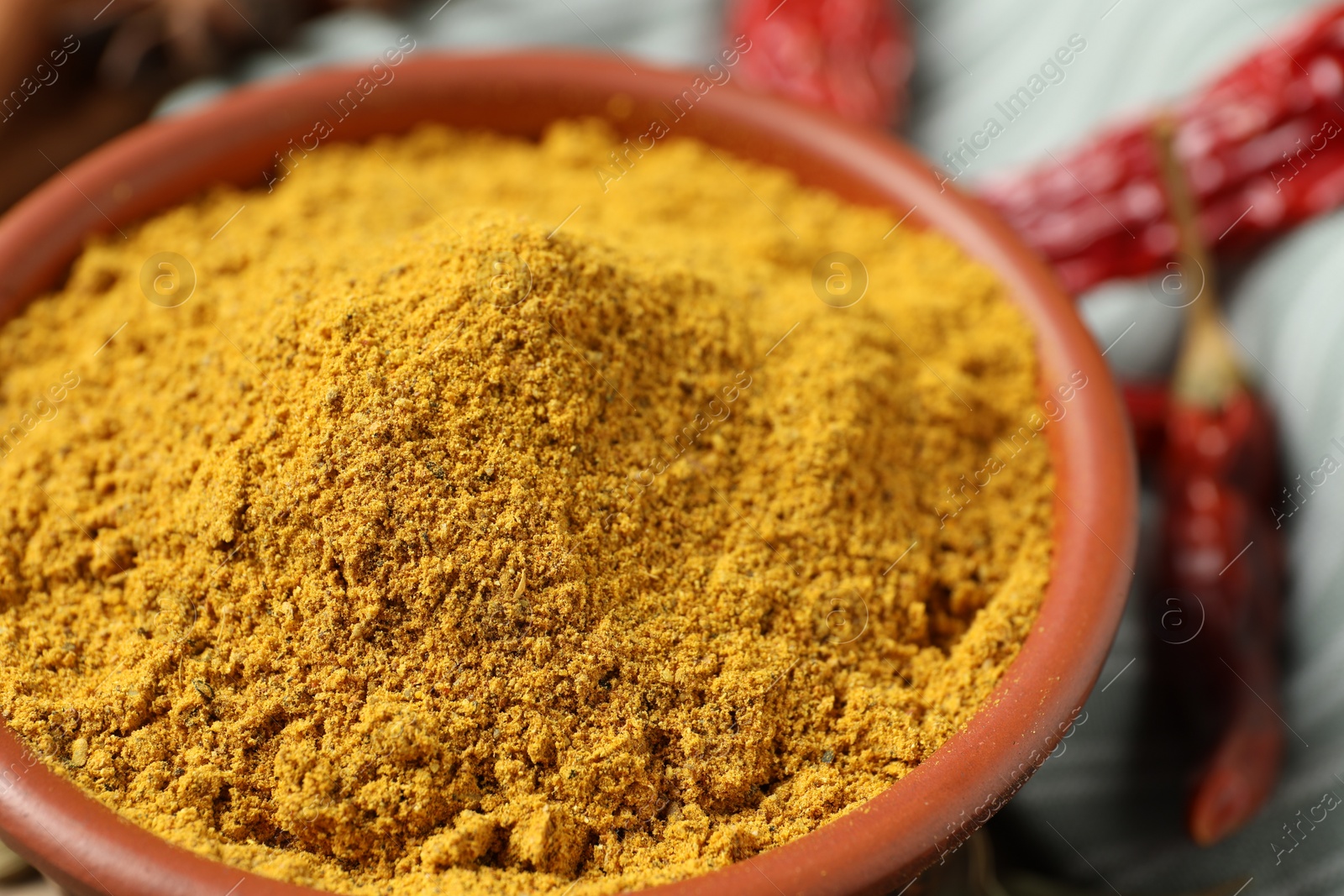 Photo of Curry powder in bowl on table, closeup