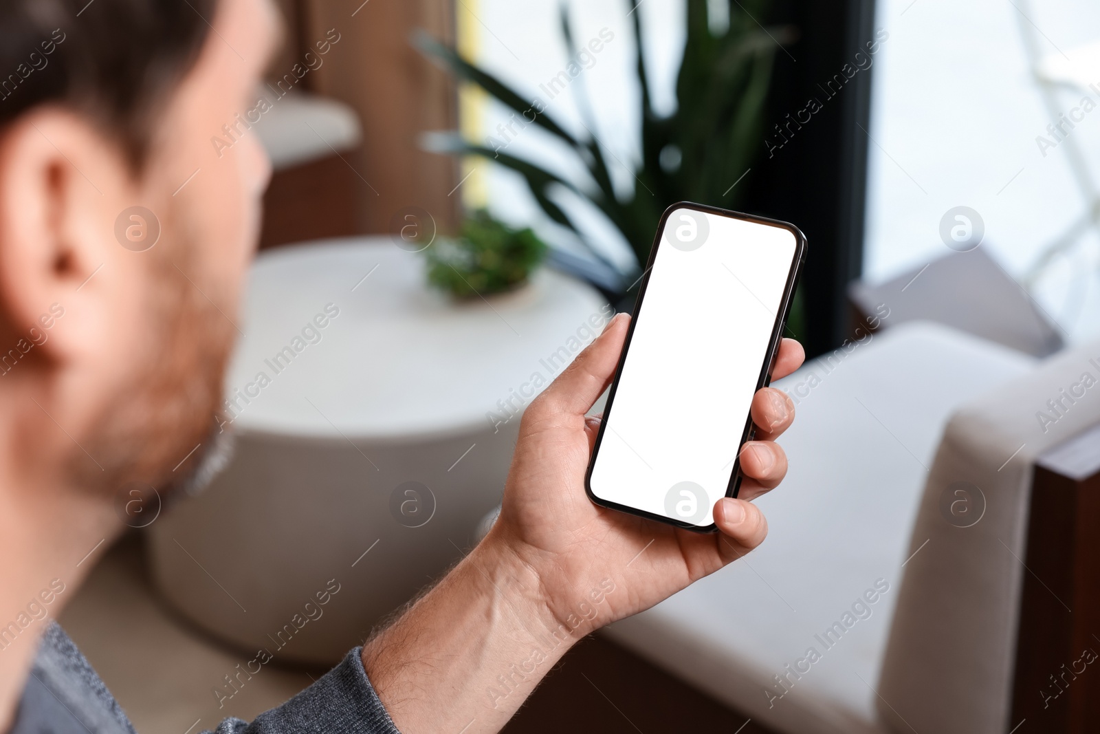 Photo of Man using smartphone in cafe, closeup view