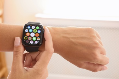 Image of MYKOLAIV, UKRAINE - SEPTEMBER 19, 2019: Woman using Apple Watch at home, closeup