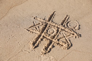 Photo of Tic tac toe game drawn on sandy beach, above view