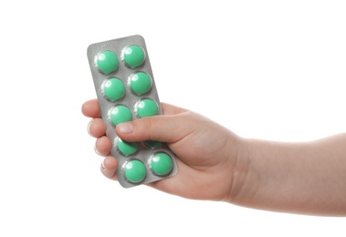 Photo of Little child with pills on white background, closeup. Danger of medicament intoxication