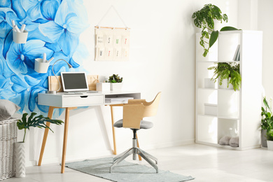 Photo of Stylish living room interior with blue flowers painted on wall. Floral pattern