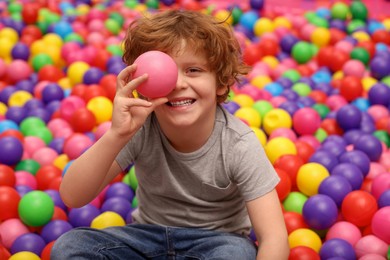 Photo of Happy little boy holding ball in play room
