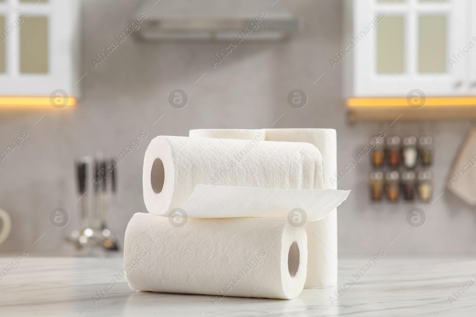 Photo of Rolls of paper towels on white marble table in kitchen