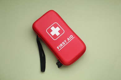 Photo of First aid kit on light green background, top view