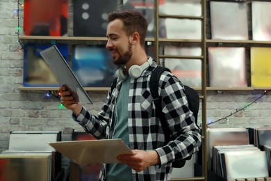 Image of Young man with vinyl records in store